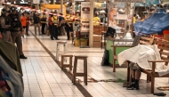 The body of a suspected shooter is covered with a sheet on a bench at Or Tor Kor Market in Bangkok on July 28, 2025. Photo by Chanakarn Laosarakham / AFP