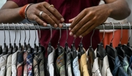 An employee arranges shirts at the apparel manufacturing unit at Bhiwandi in the Thane district of India's Maharashtra state on July 30, 2025. (Photo by Indranil MUKHERJEE / AFP)
