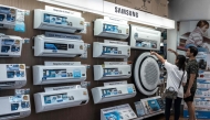 People looks at Samsung air conditioners displayed for sale at a home improvement store in Bangkok on August 1, 2025. (Photo by Chanakarn Laosarakham / AFP)
