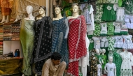 A clothing vendor waits for customers at a market in Lahore on July 31, 2025. (Photo by Arif ALI / AFP)
