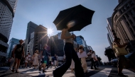 People cross a street on a hot day in Tokyo on August 4, 2025. Photo by Kazuhiro NOGI / AFP.