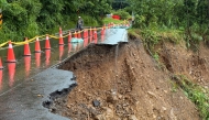 This handout taken on August 3, 2025 and released by the Kaohsiung Fire Department shows a landslide that swept away a section of road, which caused a car transporting five people to plunge into a ravine, in a mountainous area of Kaohsiung. Photo by Handout / Kaohsiung Fire Department / AFP