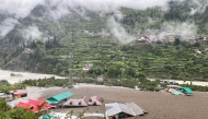 This handout photograph taken on August 5, 2025 and released by the Indian Army shows residential buildings partially submerged in sludge after a cloudburst caused a massive mudslide in India's Uttarakhand state. (Photo by Indian Army / AFP) 
