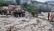 This handout photograph released on August 6, 2025 by the Indian Army shows security and relief personnel heaving rocks and removing debris to build a crossing across a stream of dense sludge during a search and rescue operation, a day after a cloudburst caused a massive mudslide and flash floods in India's Uttarakhand state.  (Photo by Indian Army / AFP) 