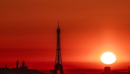 (Files) The sun rises by the Eiffel Tower and the Sacre Coeur Basilica ontop of the Montmartre hill in Paris on July 1, 2025. (Photo by Thibaud Moritz / AFP)