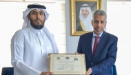 Secretary-General of the Arab Interior Ministers Council Dr. Mohammad bin Ali Kuman presenting the certificate of achievement to Vice-President of the Police Academy and Director of the Police College Lieutenant Colonel Fahd Saeed Al Subaie.