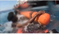 This handout video grab taken and released by the Italian Guardia Costiera on August 14, 2025, shows migrants being rescued at sea by the Guardia Costiera after their boat sank at sea off the island of Lampedusa. (Photo by GUARDIA COSTIERA / AFP)