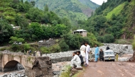 Onlookers gather near a destroyed bridge after flash floods on the outskirts of Muzaffarabad, the capital of Pakistan-administered Kashmir, on August 15, 2025. (Photo by Sajjad Qayyum / AFP)