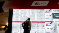 A person looks at a flight board with many cancellations for Air Canada flights at Pierre-Elliott Trudeau Airport in Montreal, Quebec, Canada, on August 17, 2025. (Photo by ANDREJ IVANOV / AFP)