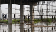 Labourers work at a flooded construction site after heavy monsson rains in Karachi on August 20, 2025. (Photo by Rizwan Tabassum / AFP)