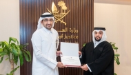Minister of Justice and Minister of State for Cabinet Affairs H E Ibrahim bin Ali Al Mohannadi with a new lawyer during the oath-taking ceremony. 