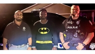 Kyle Myvett, center, poses with police officers in his Batman pajamas after detaining a burglary suspect in Cape Coral, Florida, early Wednesday morning. Cape Coral Police Department