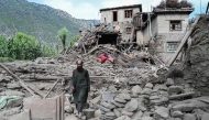 An man Afghan walks past a damaged house following earthquakes in the Mazar Dara village of Nurgal, a district of the Kunar Province, in Eastern Afghanistan, on September 1, 2025. (Photo by Wakil Kohsar / AFP)