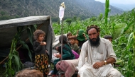 An Afghan injured man receives intravenous drips in a corn field, after earthquakes at Mazar Dara village in Nurgal district, Kunar province, in Eastern Afghanistan, on September 1, 2025. (Photo by Wakil Kohsar / AFP)