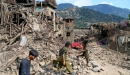 Afghans walk past damaged houses, after earthquakes at Mazar Dara village in Nurgal district, Kunar province, in Eastern Afghanistan, on September 1, 2025. (Photo by Wakil Kohsar / AFP)
