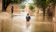 A woman wades through flood waters at a flood-hit area on the outskirts of Multan, Pakistan on Sept. 2, 2025. (Str/Xinhua)
