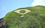 Grass mowed into the shape of a fan bearing the Japanese flag is seen on a mountain in Aso, Kumamoto Prefecture. Photo by The Japan News
