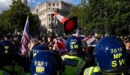A traffic cone is thrown towards police officers as supporters of British far-right activist Tommy Robinson gather during a 'Free speech' march, in central London on September 13, 2025. (Photo by Carlos Jasso / AFP)
 