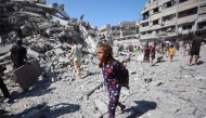 Displaced Palestinians salvage items from the rubble of the al-Ghafari tower after it was destroyed in Israeli strikes in Gaza City on September 15, 2025. Photo by Omar AL-QATTAA / AFP
