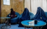 In this photograph taken on August 31, 2025, Afghan burqa-clad women, having appointments for laser treatments, sit in a waiting room at a beauty clinic in Kabul. (Photo by Wakil Kohsar / AFP)