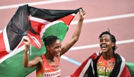 Kenya's Beatrice Chebet and Kenya's athlete Faith Kipyegon (R) celebrate after the women's 5000m final during the World Athletics Championships in Tokyo on September 20, 2025. (Photo by Philip Fong / AFP)