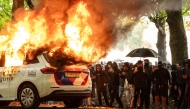A police car is set on fire during the 