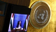 Palestinian Authority President Mahmud Abbas is displayed on a screen as he speaks remotely during a United Nations Summit on Palestinians at UN headquarters during the United Nations General Assembly (UNGA) in New York on September 22, 2025. (Photo by Angela Weiss / AFP)