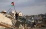 A displaced Palestinian child waves a Palestinian national flag as he stands on the rubble of a destroyed building at the Bureij camp for refugees in the central Gaza Strip on September 22, 2025. (Photo by Eyad Baba / AFP)