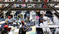 Workers operate sewing machines to stitch pieces of fabric together to make jeans inside the United Aryan textile factory at the Export Processing Zone (EPZ) in Nairobi on February 4, 2025. (Photo by Simon Maina / AFP)
