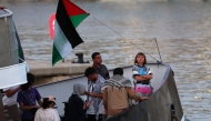 (Files) Swedish climate activist Greta Thunberg (R) is seen on board of a vessel of a civilian flotilla remains moored at Barcelona port on September 1, 2025. (Photo by Lluis Gene / AFP)
