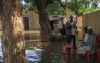 Residents sit in a pool of water due to the flooding of the Nile river in the Sudanese village of Wad Ramli north of Khartoum on October 1, 2025. (Photo by Ebrahim Hamid / AFP)

