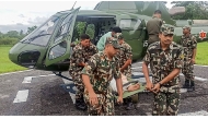 This handout photograph taken and released by Nepal's Army on October 5, 2025 shows Army personnel carrying a landslide victim evacuated by a helicoper following heavy rain-triggered landslides and floods in Nepal. (Photo by Nepalese Army / AFP) 