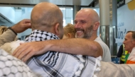 Tadhg Hickey (centre right) one of a group of Irish activists returning, is greeted by supporters as they arrive at Dublin Airport on October 7, 2025, after being deported from Israel. (Photo by Paul Faith / AFP)
