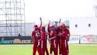 Qatar players celebrate after taking a wicket.