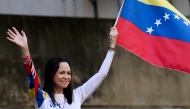 (Files) Venezuelan opposition leader Maria Corina Machado waves a national flag in Caracas on January 9, 2025. (Photo by Juan Barreto / AFP)