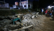 Police stand next to the rubble of a collapsed wall in Mati town, Davao Oriental province, in southern island of Mindanao, after a 7.4-magnitude earthquake struck the province. (Photo by Mark NAVALES / AFP)
