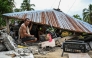 Men look for items in a collapsed house in Manay, in the province of Davao Oriental on October 11, 2025. (Photo by Jam Sta Rosa / AFP)
