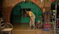 A Mexican Army soldier works to remove the mud from a flooded house due to the heavy rains in the municipality of Alamo, Veracruz, Mexico, on October 12, 2025. Photo by Hector Quintanar / AFP