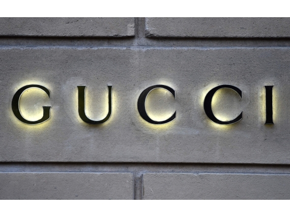 This picture taken on December 19, 2017 shows a logo outside the fashion house and luxury goods Gucci shop on the Avenue Montaigne in Paris, ahead of Christmas. Photo by STEPHANE DE SAKUTIN / AFP