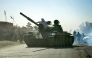 Taliban security personnel on a Soviet-era tank are followed by motorcyclists as they ride towards the border, as clashes take place between Taliban security personnel and Pakistani border forces, in the Spin Boldak district of Kandahar Province on October 15, 2025. (Photo by Sanaullah SEIAM / AFP)
