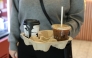 A customer holds a tray with coffee drinks in New York City on October 16, 2025. (Photo by Angela Weiss / AFP)