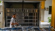 A staff member loads lunch plates on the first day of a free-meal programme at Muhammadiyah high school in Sidoarjo on January 6, 2025. Photo by Juni KRISWANTO / AFP