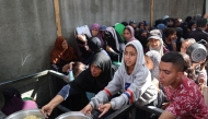 Palestinian children gather to receive food portions from a charity kitchen in the Nuseirat refugee camp, located in the central Gaza Strip, on October 21, 2025. (Photo by Eyad Baba / AFP)
