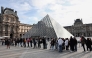 Visitors queue in front of the Pyramide du Louvre, designed by Chinese-US architect Ieoh Ming Pei, with the Louvre Museum in the background in Paris on October 22, 2025. (Photo by Thibaud MORITZ / AFP)