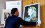 Patrick Haggenmueller, Head of the Art Investigation Unit of the Bavarian State Criminal Police Office (BLKA), displays the forged painting 'Portrait of Marie-Therese Walter with garland', offered as artwork by Spanish artist Pablo Picasso and confiscated by the police, during a presentation in the premises of the Bavarian State Criminal Investigation Department in Munich, southern Germany, on October 24, 2025. Photo by Matthias BALK / AFP