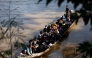 People from various countries, who were working in the KK Park compound in Myanmar, travel in a boat across the Moei river to cross over from Myanmar to Thailand, as seen from Mae Sot District, Tak Province area on October 24, 2025. (Photo by Sarot Meksophawannakul / THAI NEWS PIX / AFP)
