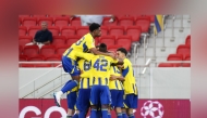 Al Gharafa players celebrate after scoring a goal.