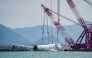 A crane hoists the recovered fuselage section of an ACT Airlines Boeing 747-400 cargo aircraft, in Hong Kong on October 26, 2025, after it veered off an airport runway on October 20 during landing. (Photo by Leung Man Hei / AFP)
