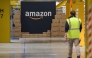 Files: An US giant Amazon employee passes by its logo on the opening day of the new distribution center in Augny, eastern France, on September 23, 2021. (Photo by Sebastien Bozon / AFP)