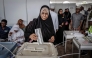 A voter casts her ballot while others queue at the Maundi voting centre in Stone Town on October 29, 2025, during Tanzania's presidential elections. Photo by Marco Longari / AFP